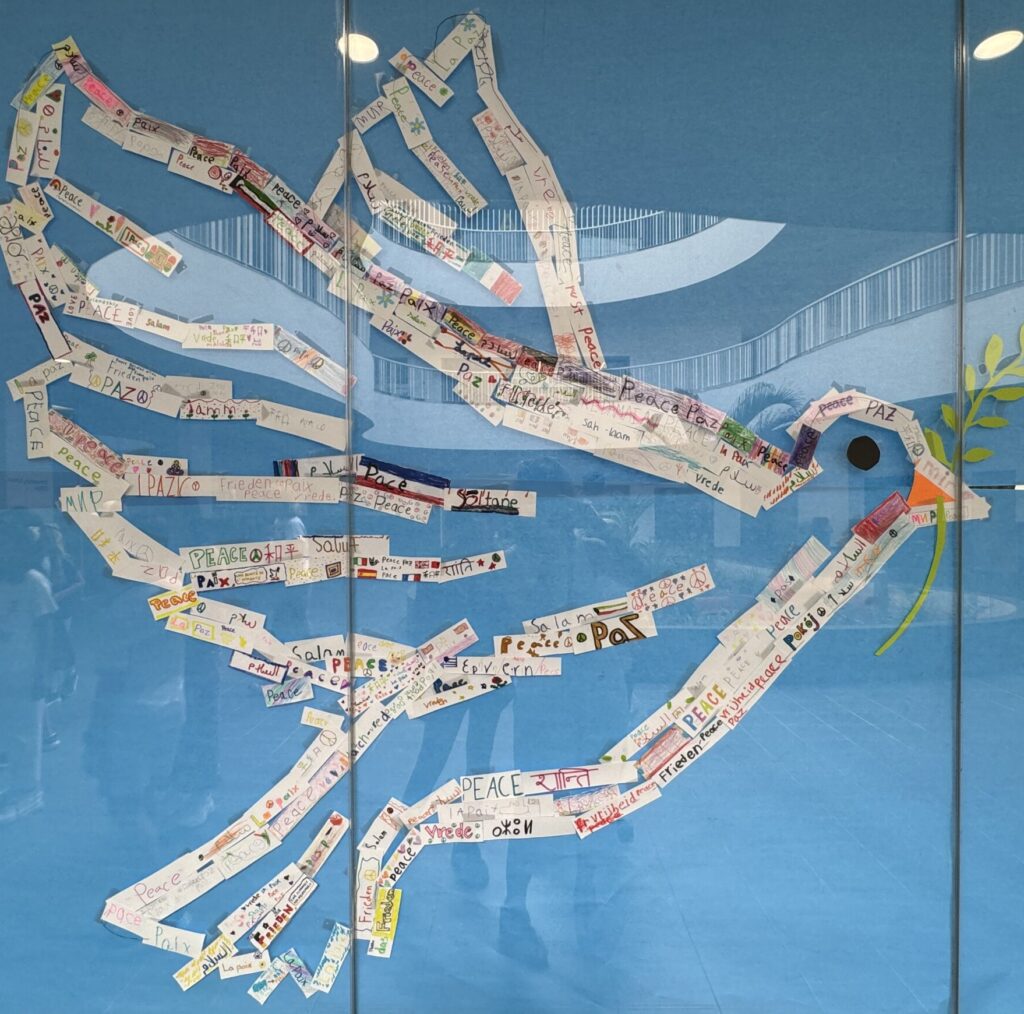 Multilingual school display featuring the word peace in many languages